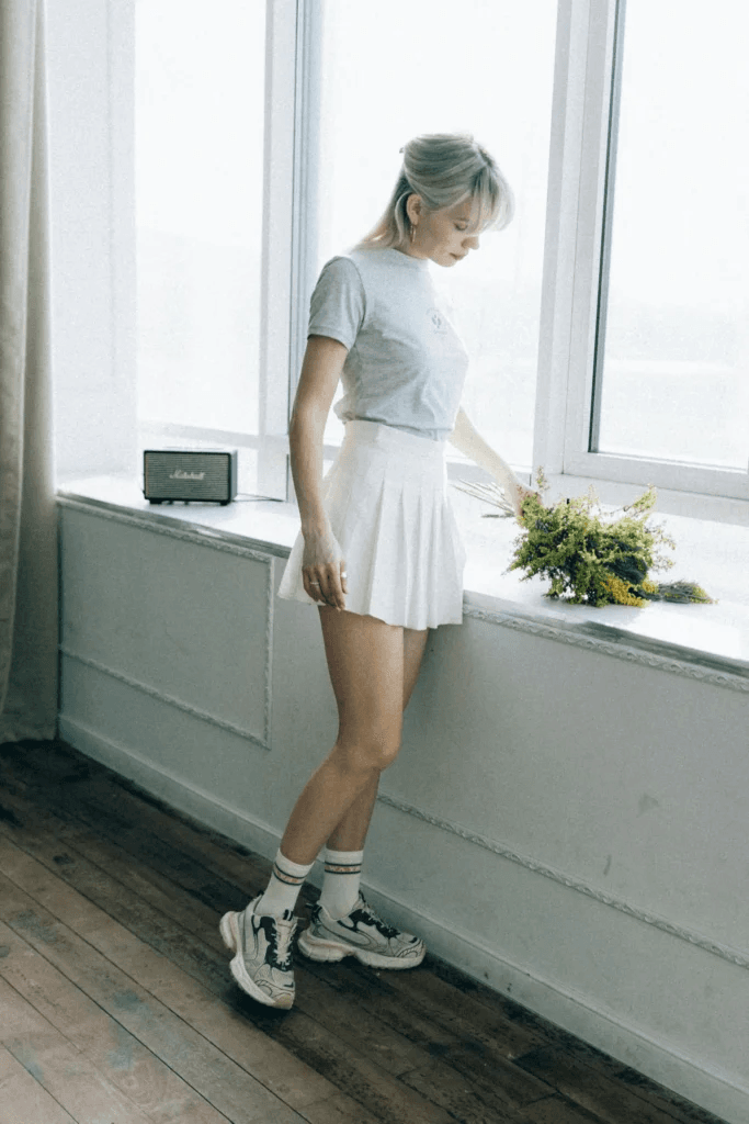  White shirt tucked into pleated mini skirt with loafers: